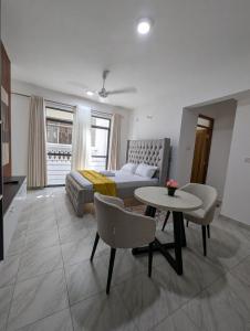 un salon avec un lit et une table dans l'établissement Nancy's Haven studio apartment, à Mombasa