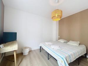 mała sypialnia z łóżkiem i biurkiem w obiekcie L'Harmonie - Appartement proche de la Gare et du Centre w mieście Narbona