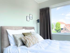 ein Schlafzimmer mit einem weißen Bett mit einem Fenster in der Unterkunft Comfortable Room in Raamsdonksveer, Free Parking in Raamsdonksveer
