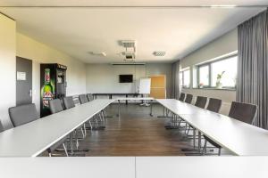 a large conference room with a long table and chairs at MEININGER Hotel Berlin Airport in Berlin