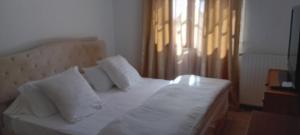 ein Schlafzimmer mit einem weißen Bett mit Kissen und einem Fenster in der Unterkunft Francois Faber in Aulnay-sur-Iton