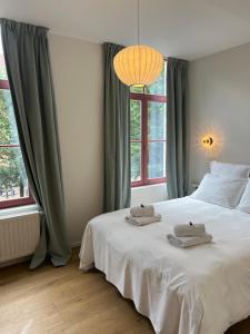 a bedroom with a white bed with two towels on it at La Senne in Brussels