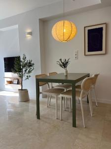 a dining room with a green table and chairs at Oliva Beach & Paradise in Playa Oliva Nova +22 photos