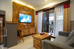 a living room with a couch and a tv at Kubu Indah Homestay Sanur in Sanur