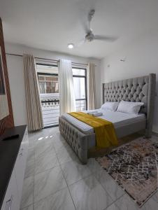 une chambre avec un grand lit avec une grande fenêtre dans l'établissement Nancy's Haven studio apartment, à Mombasa