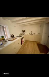 una cucina con mobili bianchi e pavimento in legno di Lovingly renovated Fishermans Cottage by the Sea a Cockburnspath Altre 8 foto
