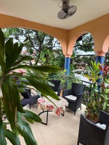 un patio con sillas, mesas y plantas en Woro Ladia, en Conakry