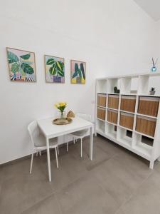 a dining room with a white table and shelves at Pepè Loft in Salerno