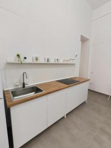 a kitchen with a sink and a wooden counter top at Pepè Loft in Salerno