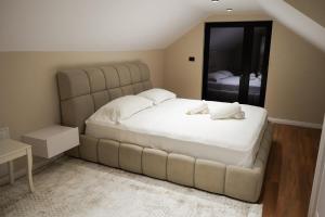 a bedroom with a large bed and a large mirror at Linza Cozy Vila in Tirana