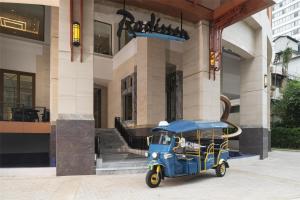 a small blue car parked in front of a building at Radisson Hotel Chateau de Bangkok in Bangkok