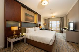 a hotel room with a large bed and a television at SAJA By Warwick Madinah Hotel in Medina +73 photos