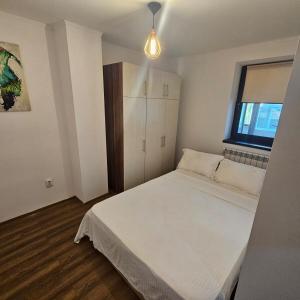 Un dormitorio con una cama blanca y una ventana. en Elegant apartment, en Tulcea