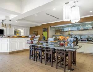 a large kitchen with a table with fruits on it at Hilton Garden Inn Wichita Airport in Wichita