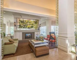 a living room with a couch and a fireplace at Hilton Garden Inn Wichita Airport in Wichita