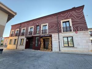 a brown and white building on a street at Hotel Rural El Majuelo in Montorio
