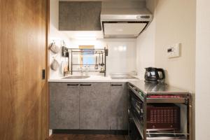 a small kitchen with a sink and a stove at GOOD DAY Shinagawa HOTEL in Tokyo