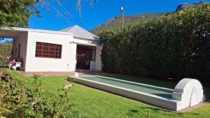 a large swimming pool in the yard of a house at La Mode Garden Cottage in Paarl