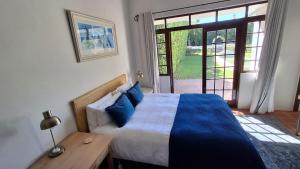 ein Schlafzimmer mit einem Bett und einem Tisch und einem Fenster in der Unterkunft La Mode Garden Cottage in Paarl