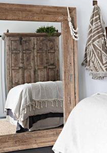 a mirror in front of a bed in a bedroom at Soul of Gerringong Cottage in Gerringong
