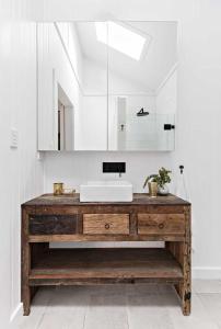 a bathroom with a sink and a mirror at Soul of Gerringong Cottage in Gerringong