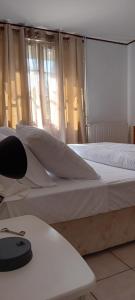 ein Schlafzimmer mit einem Bett mit weißen Laken und einem Fenster in der Unterkunft Francois Faber in Aulnay-sur-Iton