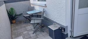 ein Paar Stühle und ein Waschbecken auf einer Terrasse in der Unterkunft FeWo Friedrichshafen in Friedrichshafen