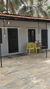 deux bancs jaunes assis à côté d'un bâtiment dans l'établissement Eagle Farmstay, à Bangalore