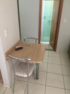 カルダス・ノバスにあるCondomínio residencial Caldas Novas flatのシャワー付きの部屋にある木製のテーブルと椅子