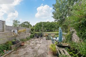 a garden with a patio with a table and an umbrella at Arundel House - Parkview with free parking in Plymouth
