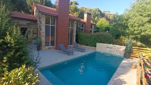 a swimming pool in front of a house at Mountscape in Bmahrāy