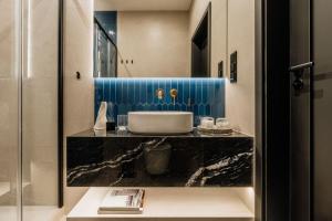 a bathroom with a sink on a black counter at Azure Palace - LoftAffair Collection in Kraków