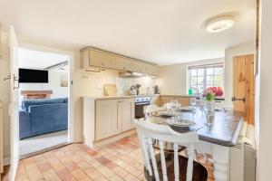 a kitchen with a table and chairs in a room at Pooles Farm Cottage in Stowmarket