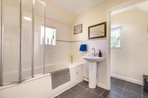 a bathroom with a shower and a sink and a tub at Pooles Farm Cottage in Stowmarket +18 photos