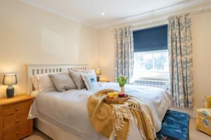 a bedroom with a bed with a window and a table at Beach House in Bembridge