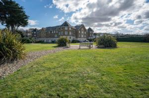 a large house with a bench in the grass at Beach House in Bembridge