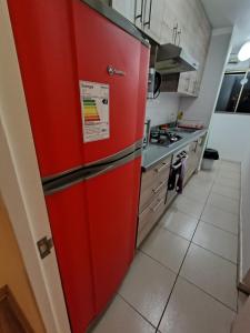 La cocina está equipada con nevera roja y fogones. en Montemar vista, en Concón 7 fotos más