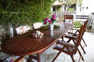 a wooden table with flowers on a patio at Malvazios Villas #2 in Gythio