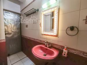 a bathroom with a pink sink and a mirror at BnBBuddy 2 BR Anugraha, Dwarka in New Delhi