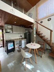 a kitchen with a table and chairs and a staircase at The Private Forest Lake Tinys Aruanda in Mata de Sao Joao +40 photos