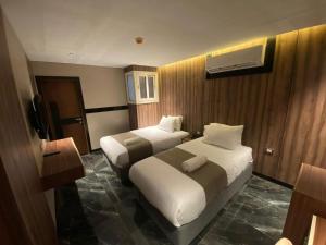a hotel room with two beds and a television at Three Pyramids View in Cairo