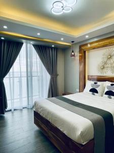 a bedroom with a large bed and a large window at Emavel Beach Resort in Balaoan