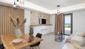 a living room with a dining table and a bed at BLUE SEA Naxos in Stelida +23 photos