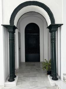 Un arco con dos columnas en una habitación con una planta. en Karisma Alcázar, en Jerez de la Frontera
