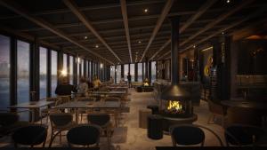 a restaurant with tables and chairs and a fireplace at Vaattunki Wilderness Resort in Rovaniemi