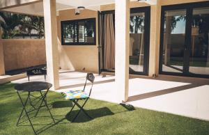 two chairs and a table in front of a house at Ayami Bay in Flic-en-Flac