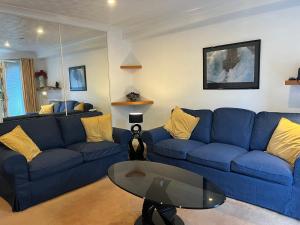 a living room with blue couches and a glass table at Marina Townhouse at Harlepool in Hartlepool