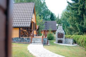 a house with a stone fireplace in the yard at Domek za Księżycem - azyl z balią, kominkiem i prywatnym ogrodem, Ustroń in Ustroń