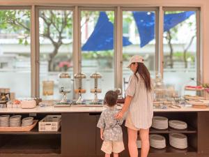 a woman and a child standing in front of a counter at Kokotel Pattaya South Beach in Pattaya