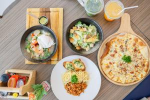 a table topped with plates of food and pasta at Kokotel Pattaya South Beach in Pattaya +34 photos